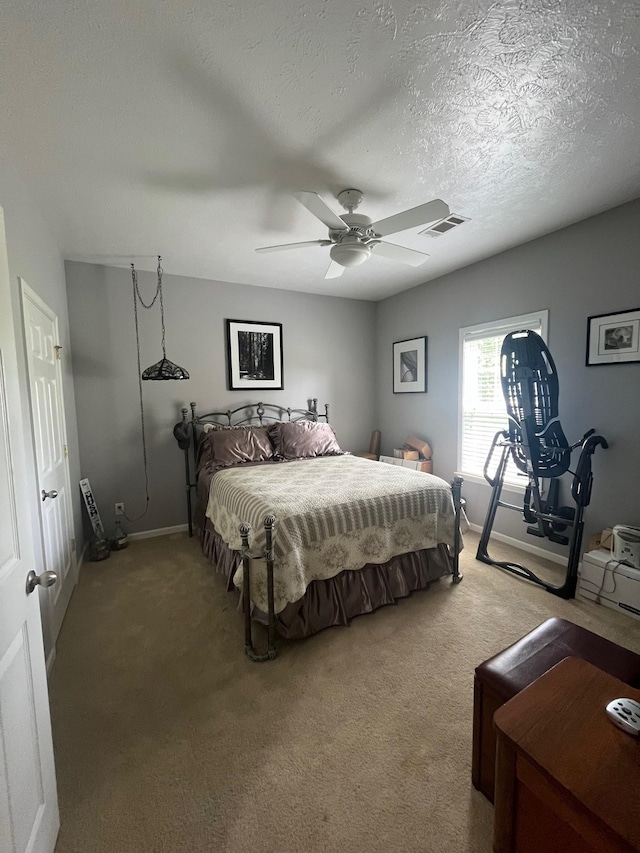 carpeted bedroom with a textured ceiling and ceiling fan