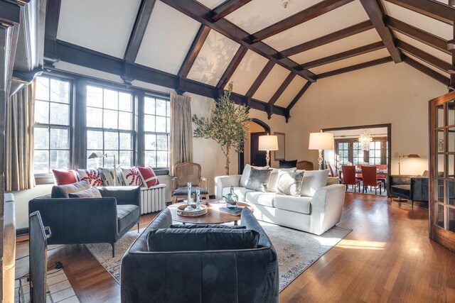 unfurnished living room featuring radiator, hardwood / wood-style floors, and high vaulted ceiling