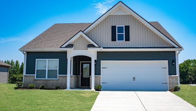 view of front of home with a garage, driveway, a shingled roof, and a front yard