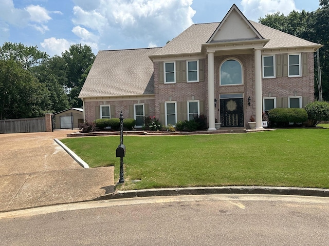 view of front facade with a garage, an outdoor structure, and a front lawn