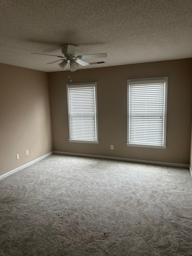 unfurnished room with a textured ceiling, ceiling fan, and carpet flooring