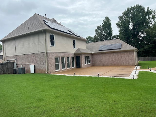 back of property featuring solar panels, a yard, and a patio area