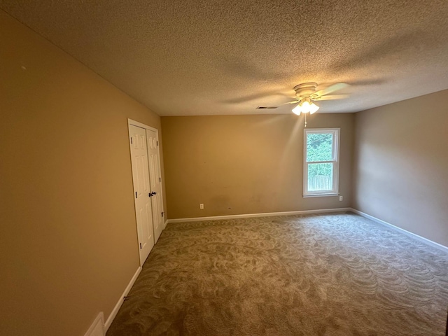 carpeted spare room with ceiling fan and a textured ceiling