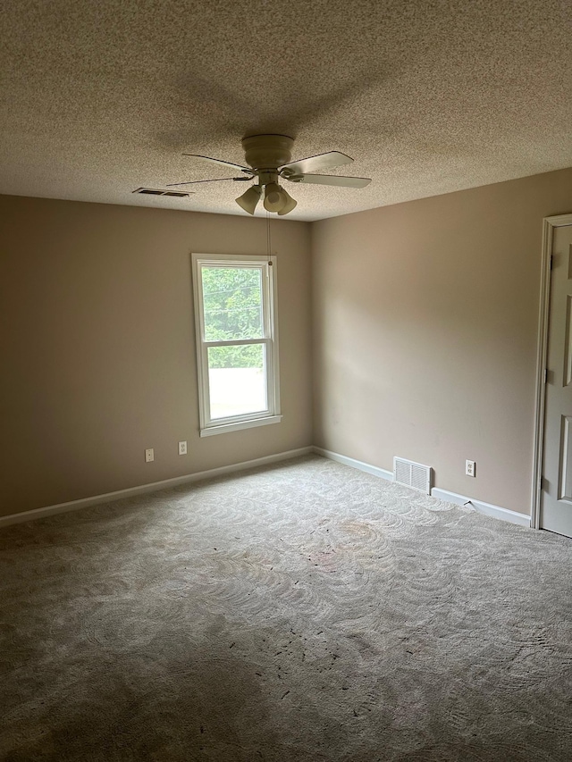 empty room featuring ceiling fan, carpet floors, and a textured ceiling