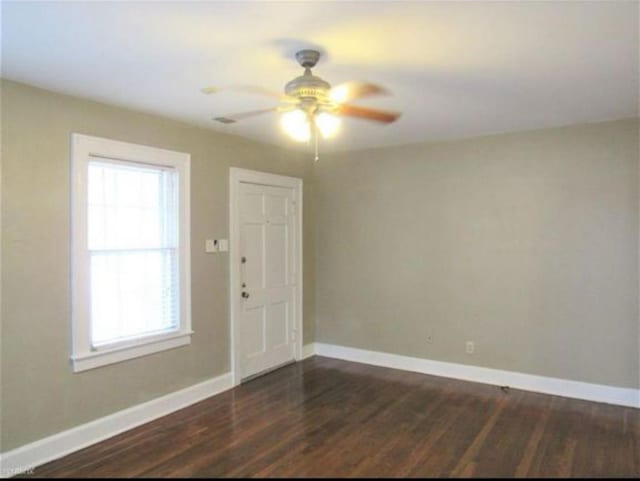 spare room featuring plenty of natural light, ceiling fan, and wood-type flooring