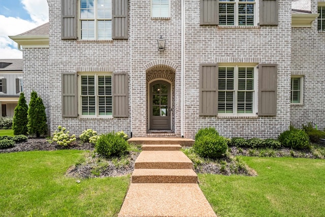 property entrance with a lawn