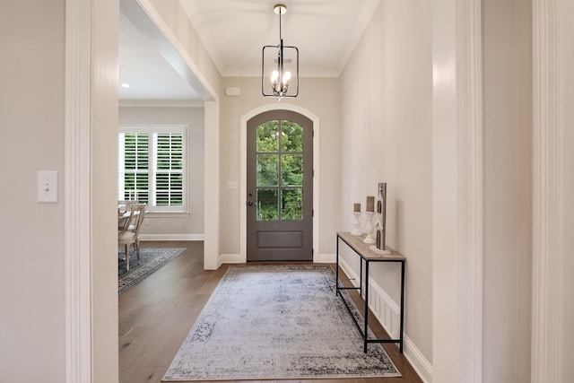 foyer featuring a notable chandelier, hardwood / wood-style flooring, and crown molding