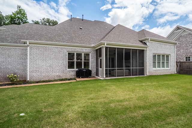 rear view of house with a sunroom and a yard