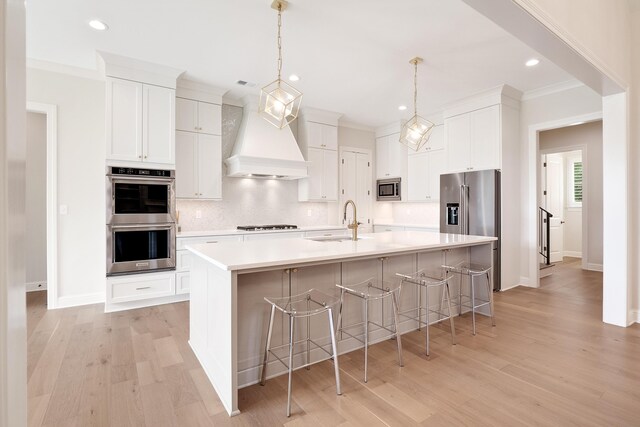 kitchen featuring stainless steel appliances, premium range hood, backsplash, and light wood-type flooring