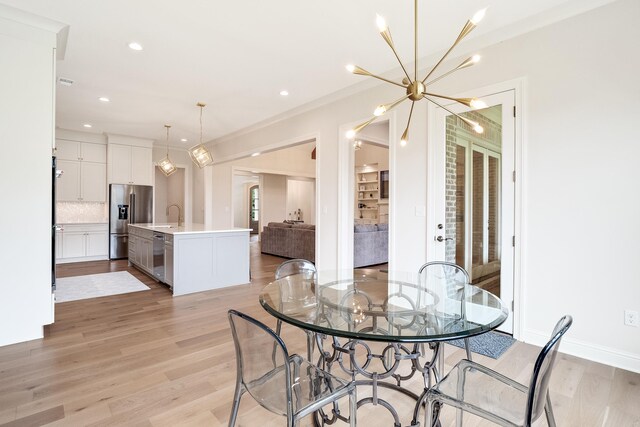 dining space with light hardwood / wood-style floors and sink