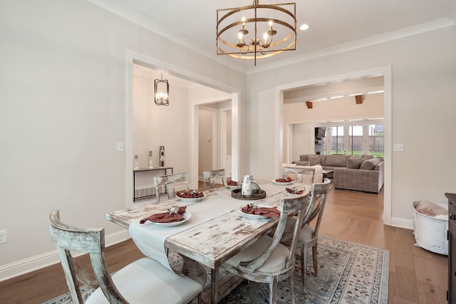 dining area featuring a notable chandelier, hardwood / wood-style floors, and ornamental molding