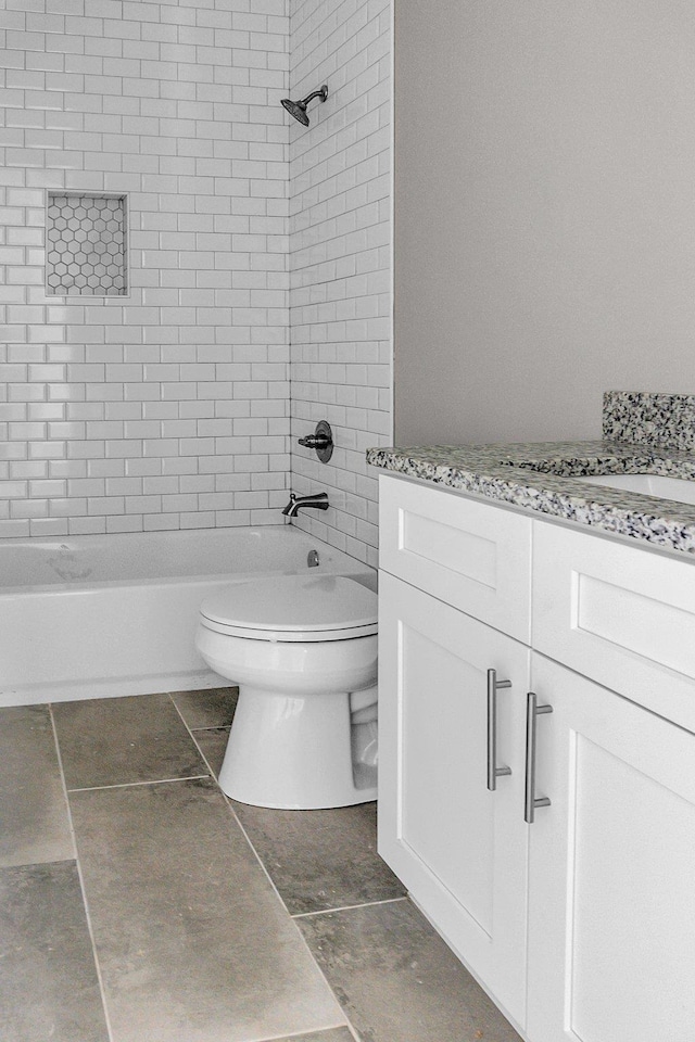 full bathroom with vanity, tile patterned flooring, toilet, and tiled shower / bath