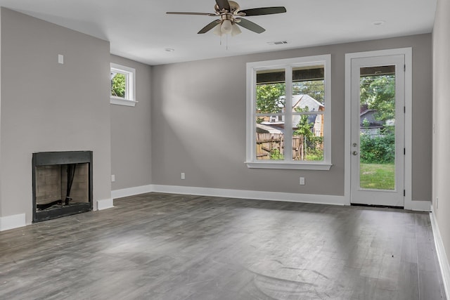 unfurnished living room featuring dark wood-type flooring and ceiling fan