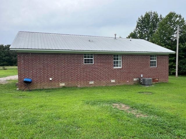 view of home's exterior with a yard and central AC