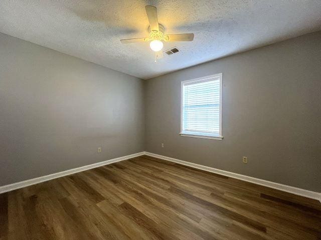 unfurnished room featuring ceiling fan, dark hardwood / wood-style flooring, and a textured ceiling