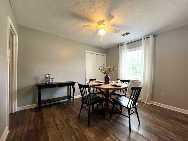 dining area featuring dark hardwood / wood-style flooring, a textured ceiling, and ceiling fan