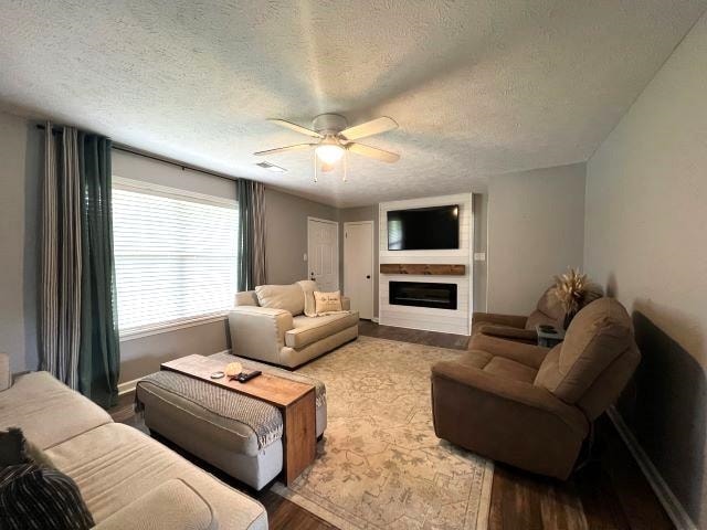 living room with wood-type flooring, a textured ceiling, and ceiling fan