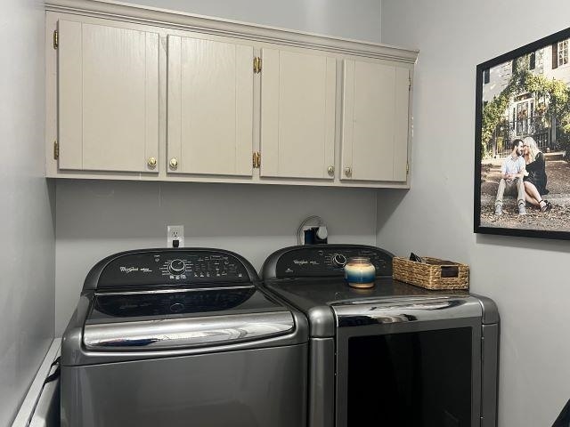 washroom with cabinets and washing machine and dryer