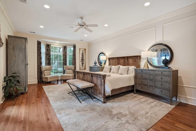 bedroom with hardwood / wood-style flooring, ornamental molding, and ceiling fan