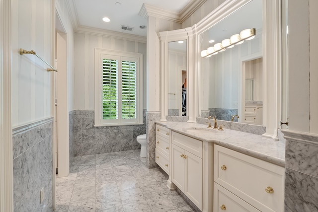 bathroom with vanity, ornamental molding, tile walls, and toilet