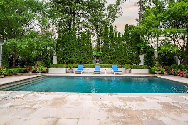 pool at dusk with a patio