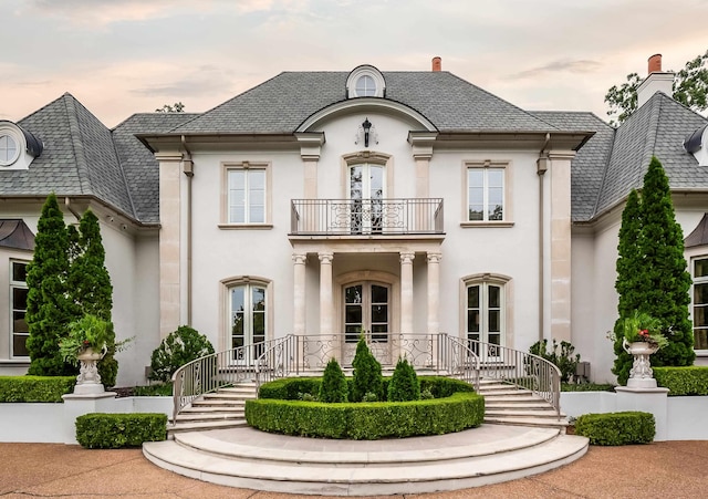 french provincial home featuring french doors and a balcony