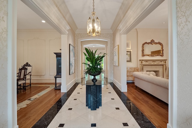 foyer entrance featuring crown molding and a chandelier