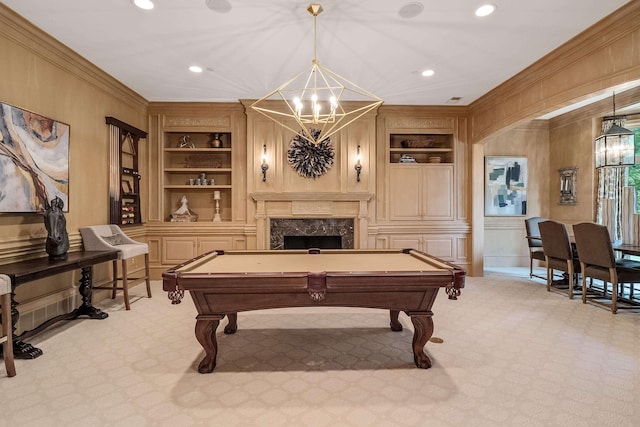 game room featuring built in shelves, ornamental molding, and light carpet