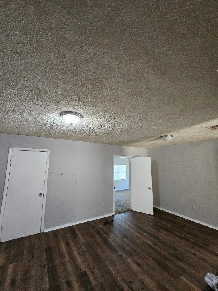 empty room featuring a textured ceiling and hardwood / wood-style floors