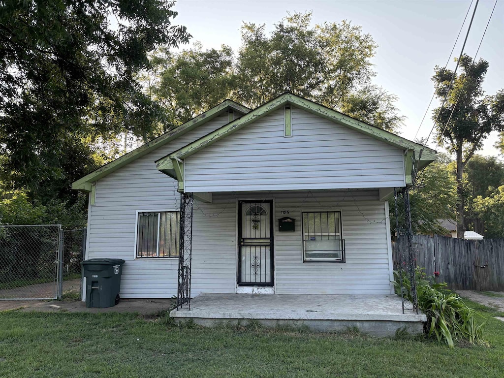 bungalow-style home featuring covered porch and a front yard