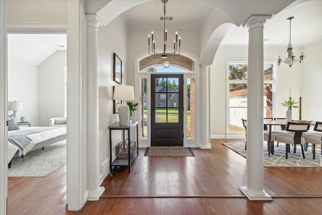 entryway with decorative columns, ornamental molding, dark hardwood / wood-style floors, and a chandelier