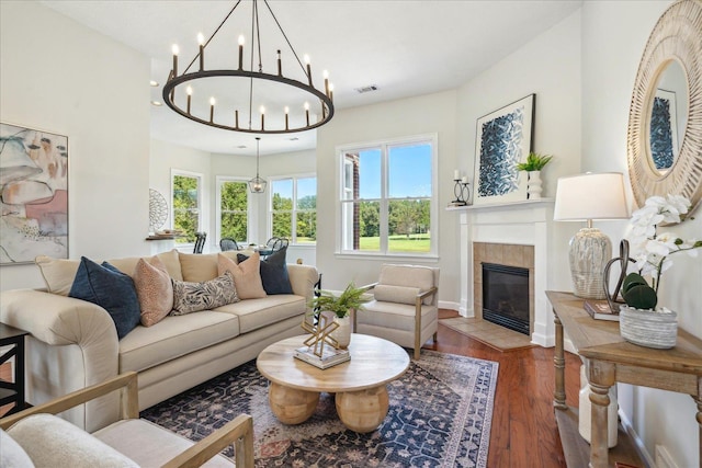 living room with a tiled fireplace and dark wood-type flooring