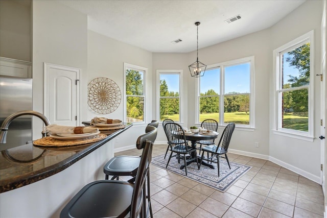 dining room featuring light tile patterned flooring, sink, and a notable chandelier