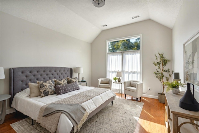 bedroom with hardwood / wood-style flooring and lofted ceiling