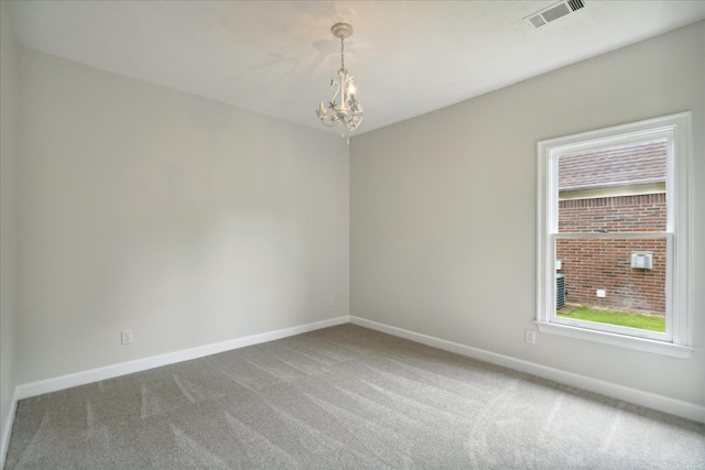 carpeted empty room with an inviting chandelier and plenty of natural light