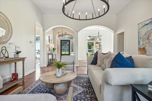 living room featuring hardwood / wood-style flooring, a high ceiling, and an inviting chandelier