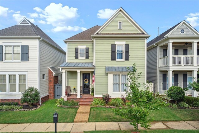 view of front of property with a balcony and a front lawn