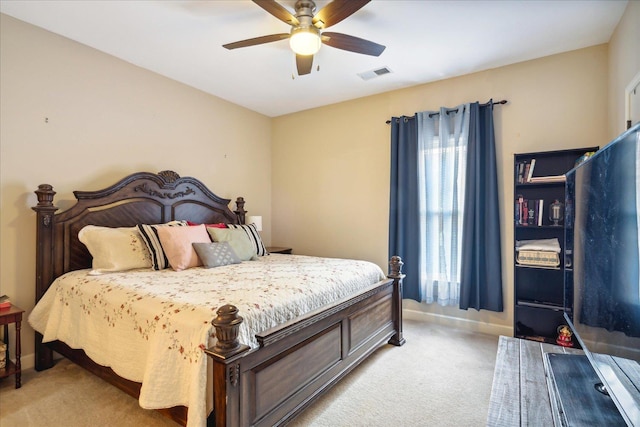 bedroom featuring baseboards, visible vents, a ceiling fan, and light colored carpet