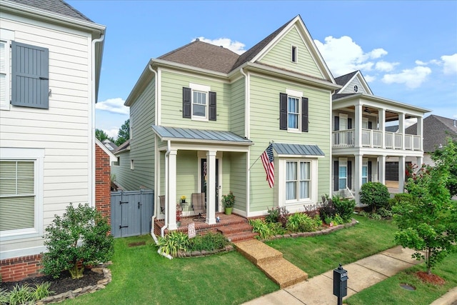 front of property featuring a balcony and a front lawn