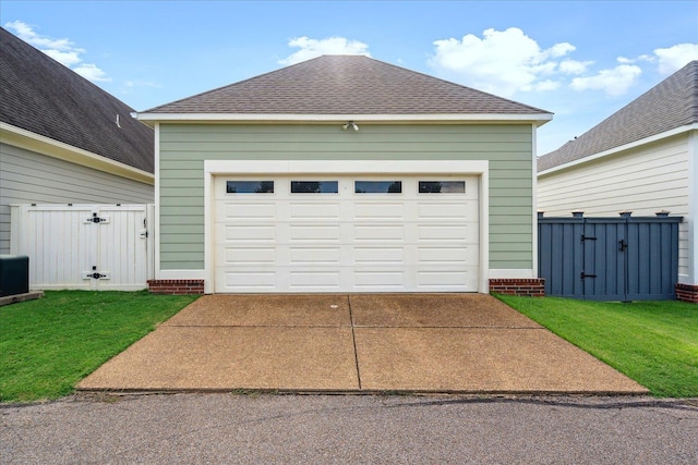 garage featuring driveway and fence