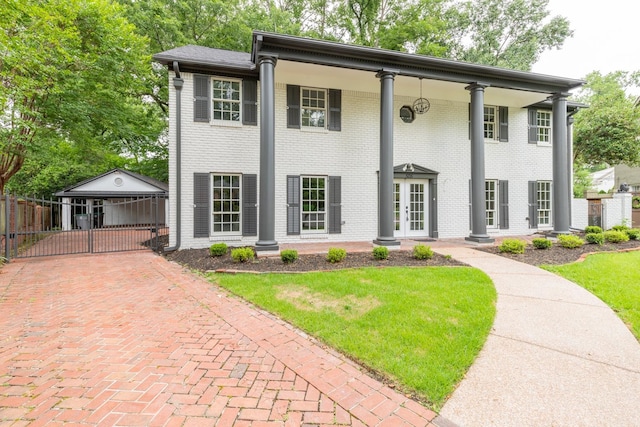 view of front of home with french doors and a front lawn