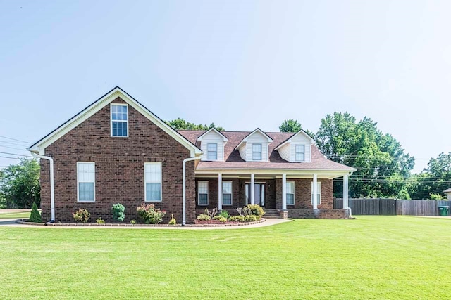 cape cod house featuring a front lawn and covered porch