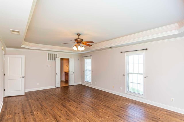 empty room featuring hardwood / wood-style flooring, ornamental molding, ceiling fan, and a tray ceiling