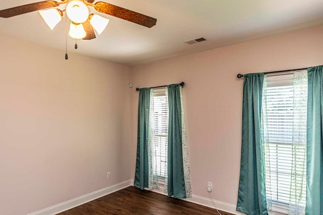 empty room with dark hardwood / wood-style floors and ceiling fan