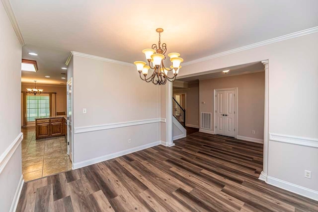 empty room with dark hardwood / wood-style flooring, crown molding, and an inviting chandelier