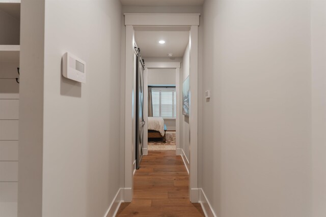 hallway with hardwood / wood-style floors and a barn door