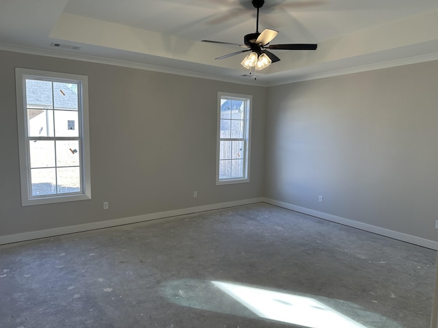 empty room with ornamental molding, a raised ceiling, and ceiling fan