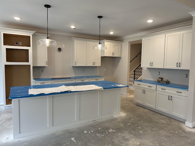 kitchen with white cabinetry, a center island, crown molding, and decorative light fixtures