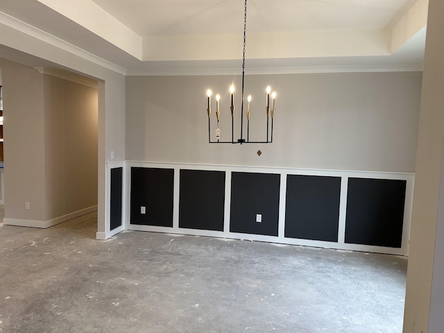 empty room with an inviting chandelier, a tray ceiling, concrete floors, and crown molding