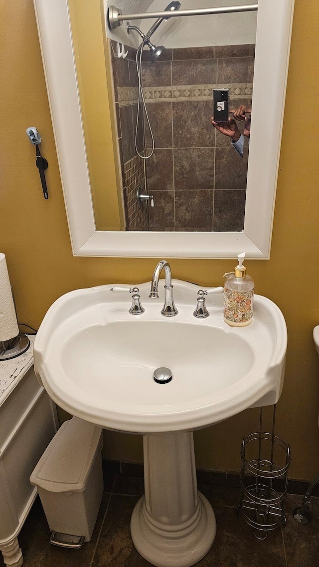 bathroom with toilet, sink, tile patterned floors, and tiled shower